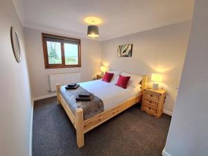 a bedroom with a wooden bed with red pillows at River Rest - Norfolk Broads in Brundall