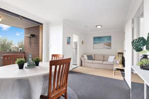 a living room with a table and a couch at Beach-side Retreat in Frankston