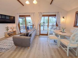 un soggiorno con divano e tavolo di River Rest - Norfolk Broads a Brundall