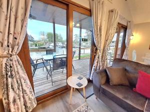 a living room with a couch and a balcony at River Rest - Norfolk Broads in Brundall