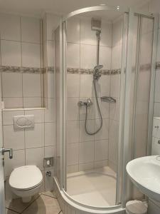 W łazience znajduje się prysznic, toaleta i umywalka. w obiekcie Norderhoog-Wohnung-Stadtblick-Nr-52 w mieście Westerland