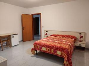 a bedroom with a bed and a table and a chair at Bellavista Apartments in Scopello