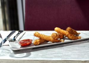 a plate with some fried food on a table at Hotel Ankaa - Adults Only in Porto Cristo
