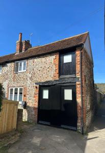 Una casa de ladrillo con dos puertas de garaje. en 14th century Rose cottage, Centre of Alfriston By Air Premier, en Alfriston