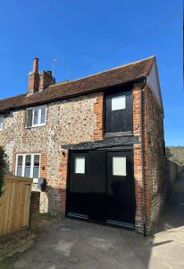 a brick house with two garage doors on it at 14th century Rose cottage, Centre of Alfriston By Air Premier in Alfriston