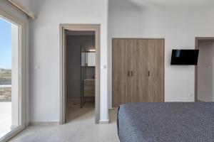 1 dormitorio con 1 cama y armario con TV en Villa Cataleya 2 PRIVATE POOL, en Fanari