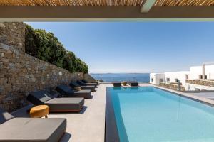 a swimming pool with chaise lounge chairs next to a building at Villa Cataleya 2 PRIVATE POOL in Fanari