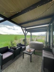 une terrasse avec des canapés, une table et un grill dans l'établissement NatureZone, à Eger