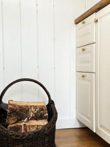 a wicker basket sitting in a kitchen next to a cabinet at Ragnar Glamp Pitrags Lux in Pitragutsiyeme