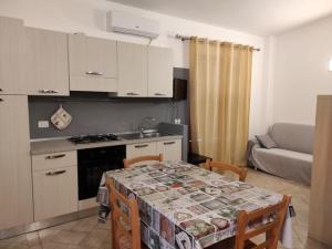 スコペッロにあるBellavista Apartmentsのテーブル付きのキッチン、ソファ付きのキッチンが備わります。