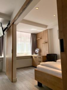 a bedroom with two beds and a window with a chair at Hotel La Fleur in Überlingen