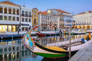 a group of boats docked in a canal with buildings at Retiro do Moliceiro in Aveiro