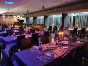 a large banquet hall with tables and chairs with candles at Hotel Admeto in Marinella di Selinunte