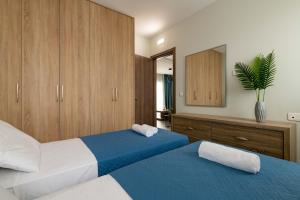 una camera con due letti e uno specchio di Tsatos Luxury Residence a Kremasti