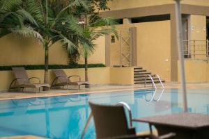 a pool with chairs and a palm tree in a building at Ufanisi Resort - Kisii in Kisii