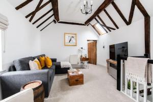 uma sala de estar com um sofá e uma televisão em Hideaway Cottage Bewdley with parking near the River Severn em Bewdley