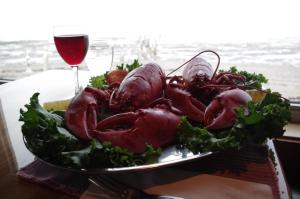 a plate of food on a table with a glass of wine at Auberge Marcel Gagnon in Sainte-Flavie