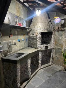 una cocina de piedra con fregadero y piedra horno en Casa aconchegante perto das praias, en Arraial do Cabo