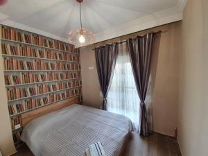 sypialnia z łóżkiem i oknem z książkami w obiekcie Rotonda citycenter two rooms apart.New renovated! w Salonikach