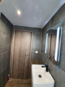 łazienka z umywalką, lustrem i drzwiami w obiekcie Rotonda citycenter two rooms apart.New renovated! w Salonikach