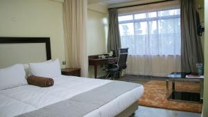 KisiiUfanisi Resort - Kisii的一间卧室，配有一张床、一张书桌和一扇窗户