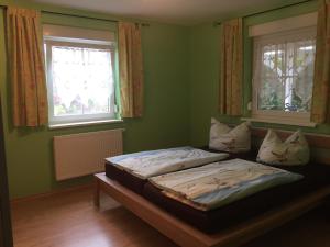 2 letti in una camera verde con due finestre di Ferienhaus Anja a Glowe