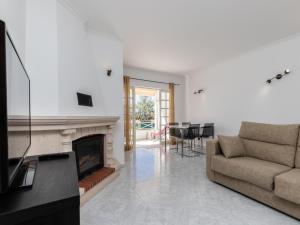 a living room with a couch and a fireplace at Akisol Albufeira Water in Albufeira