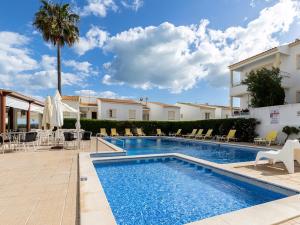 a swimming pool in a resort with chairs and a palm tree at Akisol Albufeira Water in Albufeira