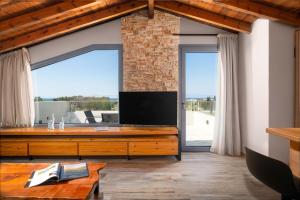 a living room with a tv and a large window at Tsatos Luxury Residence in Kremasti