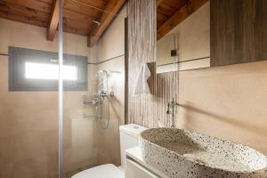 a bathroom with a toilet and a glass shower at Tsatos Luxury Residence in Kremasti
