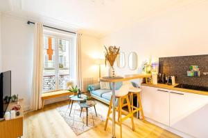 eine Küche mit einem Tisch und einem Sofa in einem Zimmer in der Unterkunft GuestReady - Lovely urban retreat in the 17th Arr. in Paris