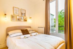 Schlafzimmer mit einem großen Bett und einem Fenster in der Unterkunft GuestReady - Lovely urban retreat in the 17th Arr. in Paris