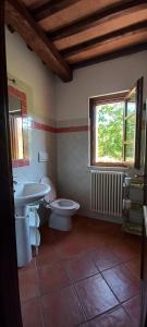 a bathroom with a sink and a toilet and a window at Casa indipendente in paese con giardino in Saturnia