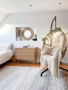 una camera da letto con una sedia in vimini e un comò di Happy Land a Londra