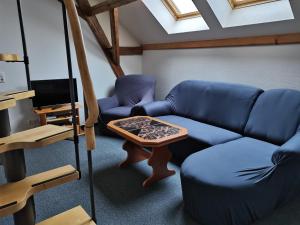een woonkamer met een blauwe bank en een tafel bij Ferienwohnungen Hering in Kleingießhübel
