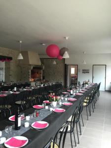 a long table with black tables and chairs in a room at Gite Clos Robin in Torcé-en-Charnie