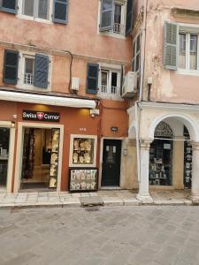 una calle de la ciudad con un edificio y una tienda en Casa di fiore en Corfú