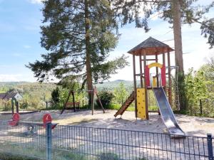 un parque infantil con un tobogán y una torre en Ferienwohnung Fuchs, en Kadenbach