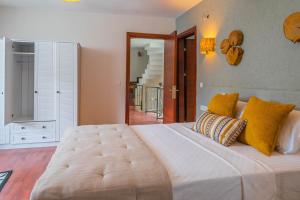 1 dormitorio con 1 cama blanca grande con almohadas amarillas en Marmaris Private Villa-Villa Lufu, en Marmaris
