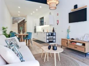 ein Wohnzimmer mit einem weißen Sofa und einem Tisch in der Unterkunft CASA OFICINA - Praia & Centro (300m) - WiFi - AC in Carvoeiro