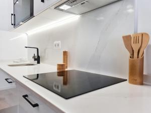 a kitchen with a glass counter top and a sink at CASA OFICINA - Praia & Centro (300m) - WiFi - AC in Carvoeiro