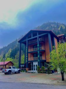 een auto geparkeerd voor een gebouw bij Akpinar Hotel in Uzungol