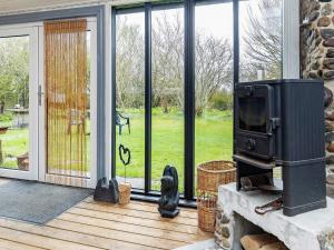 een woonkamer met een open haard en een tv op een veranda bij Holiday home Hjørring XXXV in Hjørring