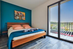 ein Schlafzimmer mit einem Bett und einem großen Fenster in der Unterkunft LES ROCHES DE BAUDISSET in Saint-Paul-en-Forêt