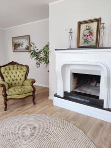 a living room with a fireplace and a chair at Amrai in Ventspils