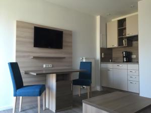 a kitchen with a table and two blue chairs at Appartementanlage Zur Seemöwe in Insel Poel