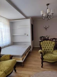 a bedroom with a bed and two chairs at Amrai in Ventspils