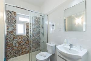 a bathroom with a toilet and a sink and a shower at Casa do Coral - Praia da Luz in Luz +21 photos
