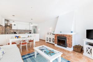 a living room with a fireplace and a table at Casa do Coral - Praia da Luz in Luz