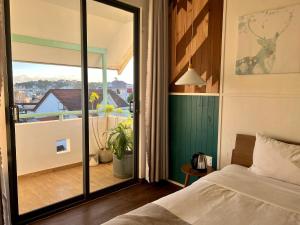 a bedroom with a bed and a view of a balcony at The Scent Boutique Dalat Hotel in Da Thien